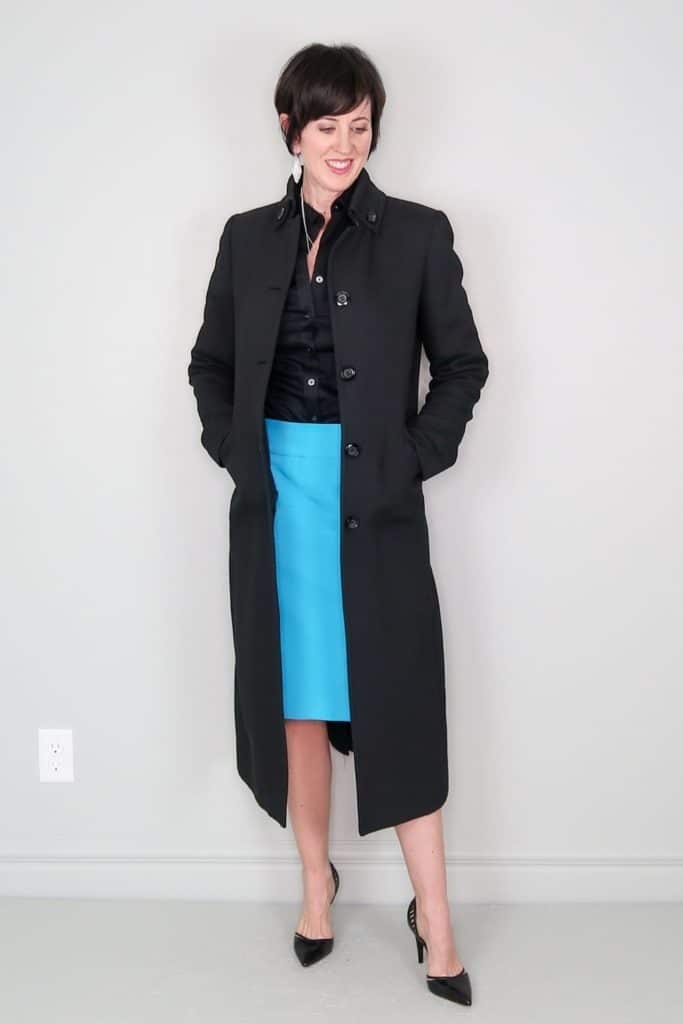 April from Stunning Style showing off her affordable wardrobe by wearing a long black wool coat and blue skirt.