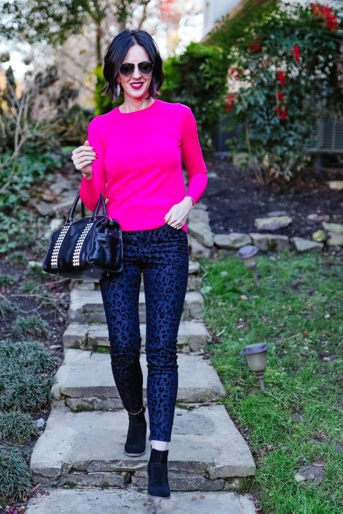 April from Stunning Style wearing pink top and dark leopard print pants with leather handbag.