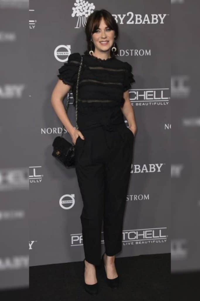 Zooey Deschanel wearing a black top with puff sleeves as part of her signature silhouette.
